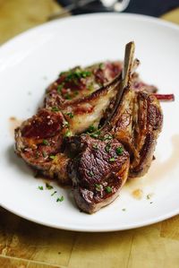 Close-up of lamb served in plate on wooden table