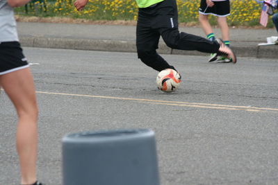 Low section of friends playing with ball in background