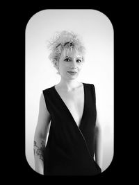 Portrait of young woman against black background