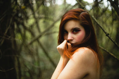 Portrait of topless woman standing in forest