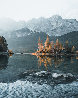 Scenic view of lake by snowcapped mountains against sky