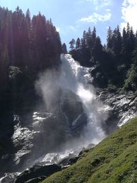 Scenic view of waterfall against sky