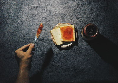 Cropped image of hand applying jam