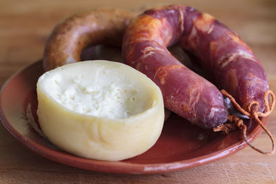 Sheep's milk cheese from azeitao and portuguese smoked sausage on clay plate