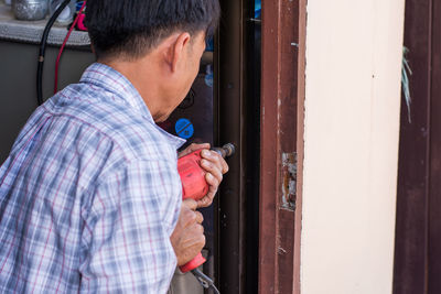 Midsection of man holding car door