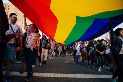 People standing on multi colored umbrella