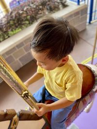 Side view of boy playing in carousel. amusement park