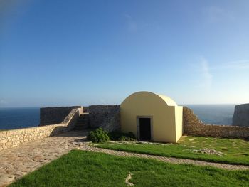 View of built structure on landscape against blue sky