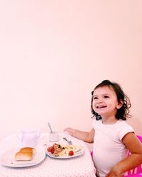 Smiling girl having breakfast at home