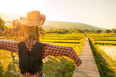 Scarecrow in farm against sky during summer