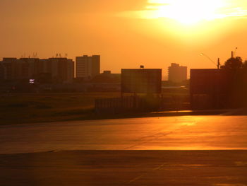 Silhouette cityscape against sky during sunset