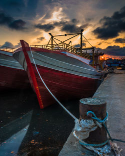 Boat moored at harbor against sky