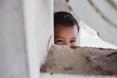 Close-up portrait of cute boy peeking