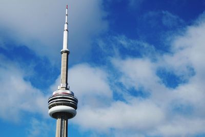 Low angle view of communications tower against cloudy sky