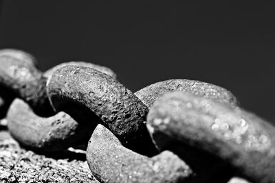 Close-up of rusty chain against black background