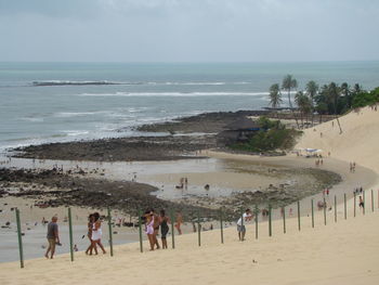 People at beach against sky