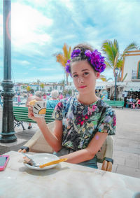 Portrait of young woman sitting on table at restaurant