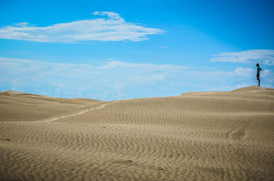 Scenic view of desert against cloudy sky