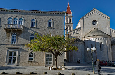  view of trees by building against sky in old town