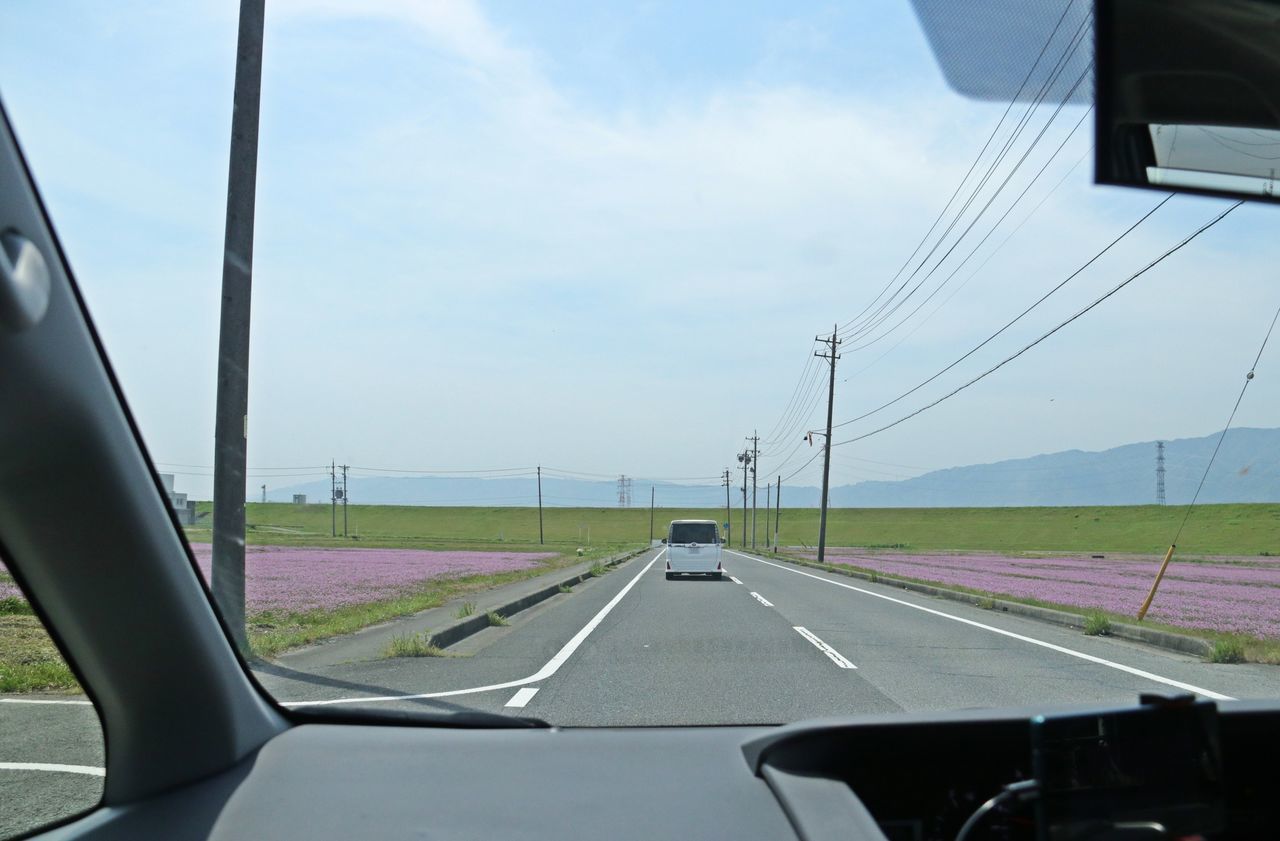 ROAD SEEN THROUGH WINDSHIELD OF CAR