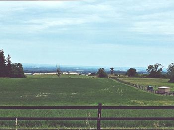 Scenic view of grassy field against cloudy sky