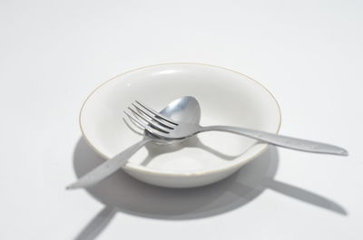 Close-up of empty plate on table against white background