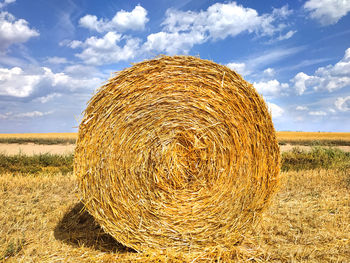 Hay bales on field against sky