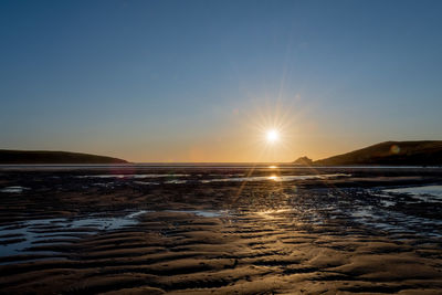 Landscape photo of the sun setting over crantock beach in cornwall