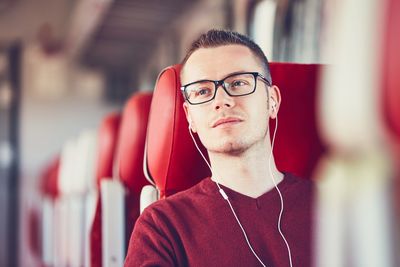 Young man listening to music while traveling in train