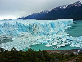 Scenic view of perito moreno glacier and mountain against cloudy sky