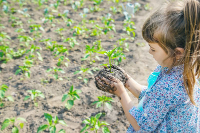 Smiling girl holding mud with plant