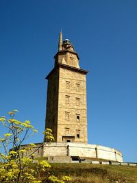 Low angle view of clock tower against blue sky