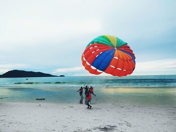 People on beach against sky