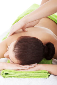 Cropped hands of woman giving massage to customer against white background