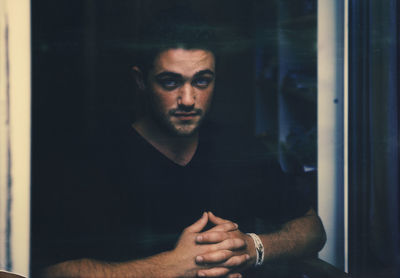 Portrait of young man in glass window