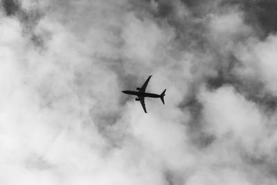 Low angle view of silhouette airplane flying in sky