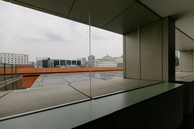 Buildings against sky seen through glass window