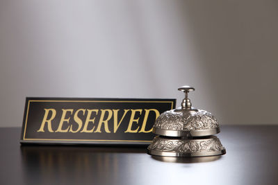 Close-up of reserved place card with service bell on table