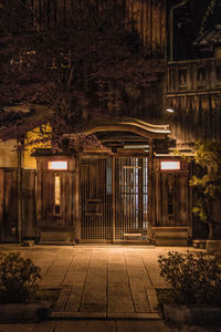 Illuminated street light by building in city at night