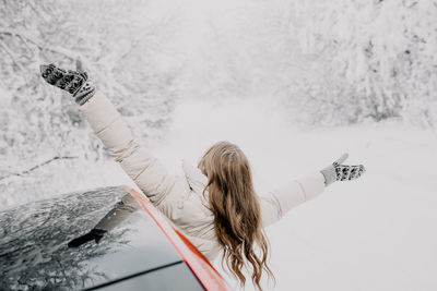 Rear view of woman standing in snow