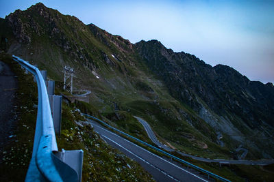 Scenic view of road by mountains against sky