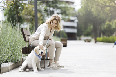 White dog with woman sitting at park