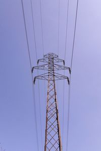 Low angle view of electricity pylon against clear sky