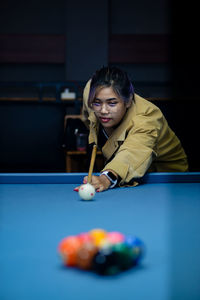 Portrait of woman playing pool