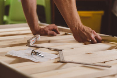 Cropped hands of man working on wood at home