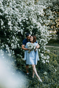 Happy romantic couple in love walking kissing in a blooming spring park