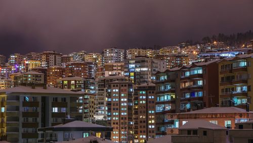 Illuminated buildings against sky at night