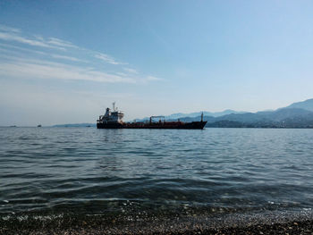 Scenic view of sea and ship against sky