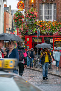 People on street against buildings in city