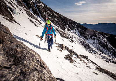 Person skiing on snowcapped mountain against sky